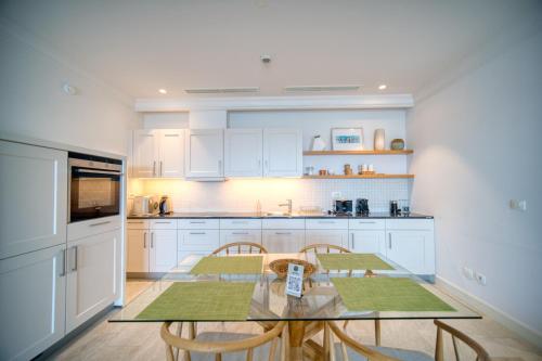 a kitchen with a glass table and two chairs at Lustica Bay Marina Village by 2BHome in Lustica