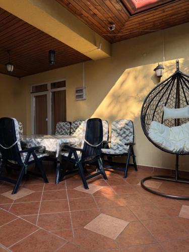 a waiting room with chairs and a swing at Blanka Vendégház in Abádszalók