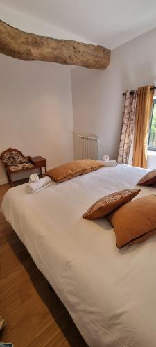 un grand lit blanc dans une chambre avec une fenêtre dans l'établissement Métairie du Château Berthe, à Aussillon