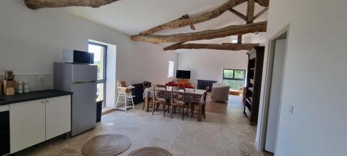 une cuisine et une salle à manger avec une table et un réfrigérateur dans l'établissement Métairie du Château Berthe, à Aussillon