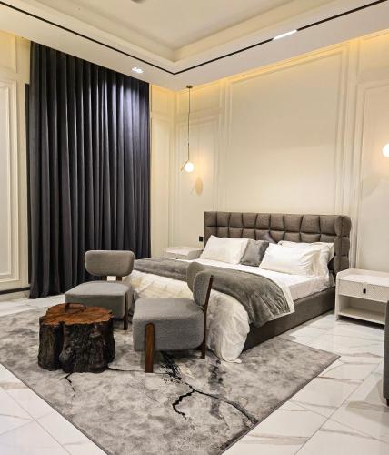 a bedroom with a bed and a table and a tree stump at The White Suites in Karachi