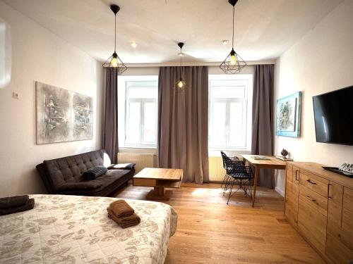 a living room with a bed and a couch and a table at Atelier Lomani in Vienna