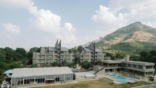 a resort with a mountain in the background at Mountain Shadow Resort in Igatpuri