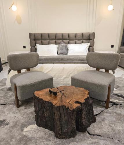 a bedroom with a bed and a tree stump coffee table at The White Suites in Karachi