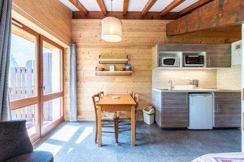 une petite cuisine avec une table et un réfrigérateur dans l'établissement Studio 15 - La Marmotte, à Cohennoz