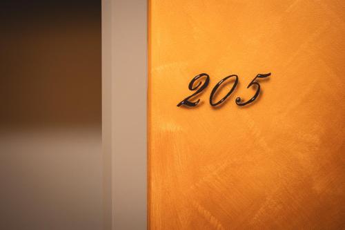 a wooden door with the number on it at Palazzo Canetti Locarno - Piazza Grande - Suites & Rooms - Easy Self Check-In in Locarno