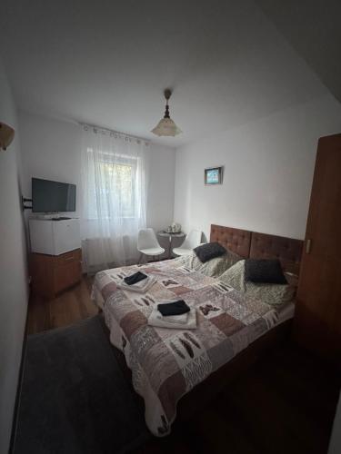 a bedroom with a large bed and a television at Pensjonat E&M in Mikołajki