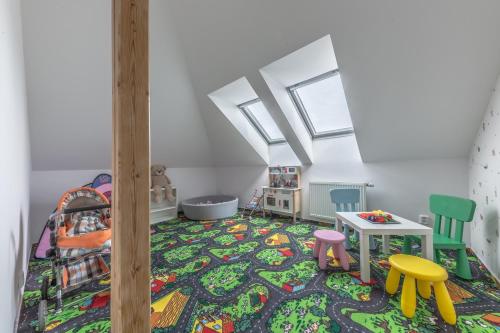 a room with a bed and a table and chairs at Vila Hamrska in Velké Hamry