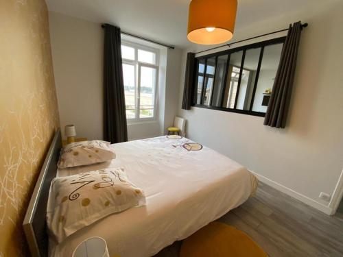 une chambre avec un lit avec des oreillers et une fenêtre dans l'établissement Vue mer en plein cœur de Morgat, à Crozon