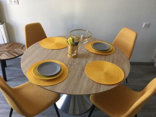 une table en bois avec des chapeaux jaunes et des assiettes dessus dans l'établissement Vue mer en plein cœur de Morgat, à Crozon