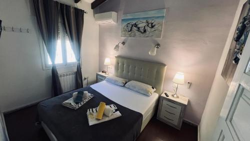 a small bedroom with a bed and a nightstand with two towels at Casa Tanja in Teulada