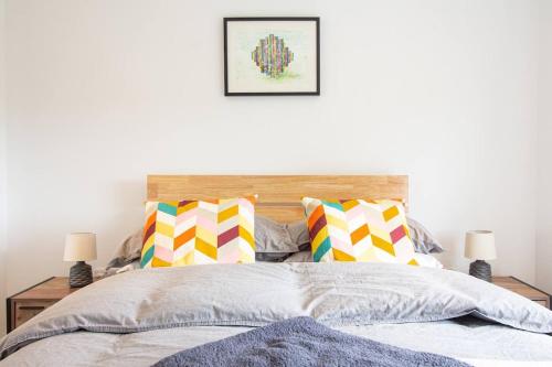a bedroom with a bed with colorful pillows at Zest Homes 87b Bridge Street in Leominster