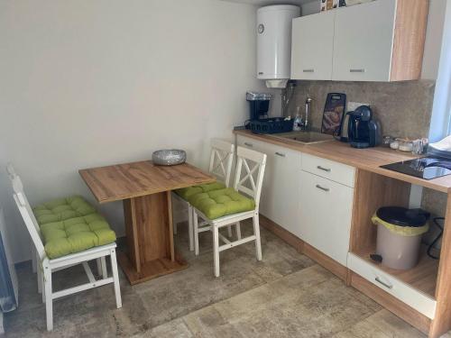 a small kitchen with a wooden table and chairs at Apartman Roko in Tribunj