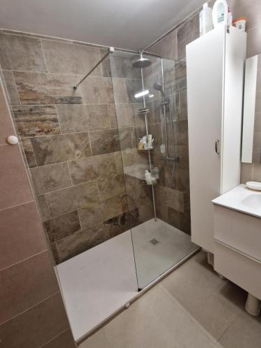 une douche avec une porte vitrée dans une salle de bain dans l'établissement Appartement vue Rhune - Piscine, à Hendaye