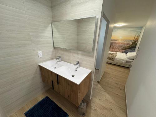 une salle de bain avec un lavabo et un miroir dans l'établissement Les nuits étoilées, à Saint-Georges-dʼOléron