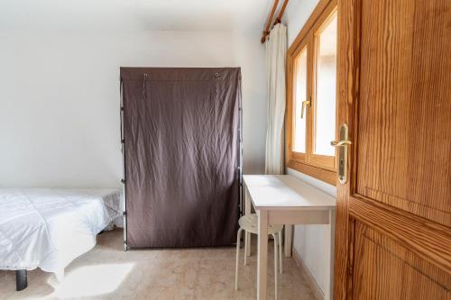 a bedroom with a bed and a desk and a window at Alt Son Lliure beautiful village house in Valldemossa in Valldemossa
