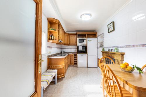 a kitchen with wooden cabinets and a wooden table with chairs at Alt Son Lliure beautiful village house in Valldemossa in Valldemossa
