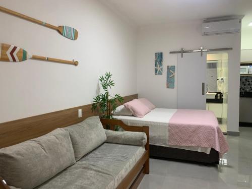 a living room with a couch and a bed at Amarílis Riviera-Estúdio A-209 in Bertioga