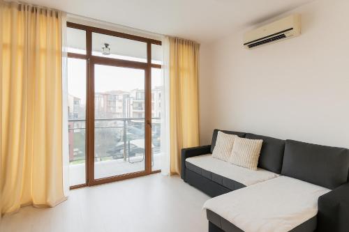a living room with a couch and a large window at Helios Seaview Apartment in Sveti Vlas
