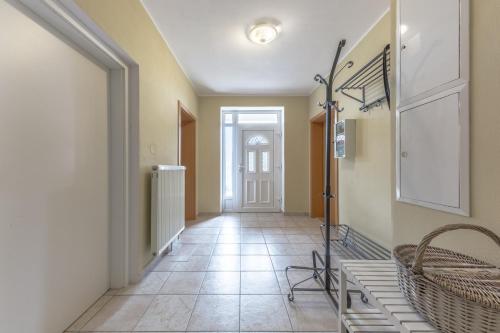 a hallway with yellow walls and a tile floor at Vila Hamrska in Velké Hamry