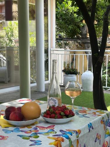 - une table avec une assiette de fruits et une bouteille de vin dans l'établissement La Mascotte, à Nice