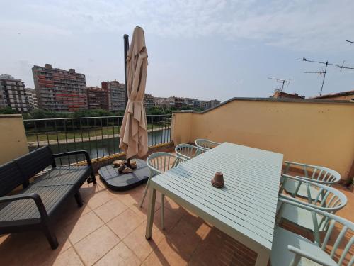 a blue table and chairs and an umbrella on a balcony at APARTAMENT CASA MONTROIG in Balaguer