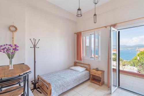 a bedroom with a bed and a table and a balcony at Christianna studios in Nikiana