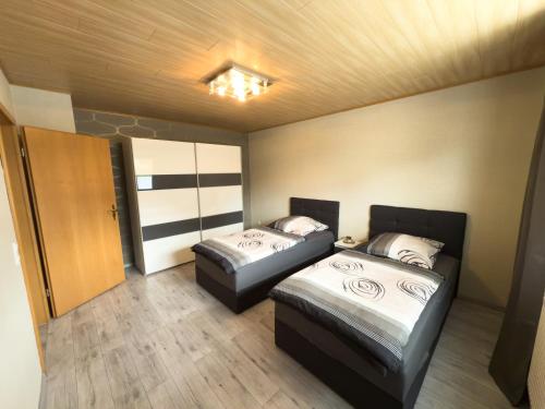 two beds in a small room with a door at Luxury Apartment Kelberg Nähe Nürburgring in Kelberg