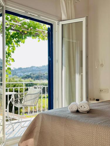 a bedroom with a bed and a sliding glass door at Andros Tierra Apartments in Batsi