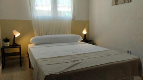 a bed in a room with two lamps and a window at Usera Habitaciones B in Madrid