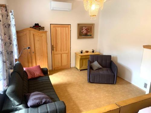 a living room with a couch and a chair at Chalupa Na Studené Vodě 