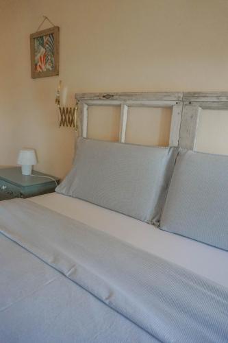 a bedroom with a bed with white sheets and a window at B&B La Buonora in Sinio