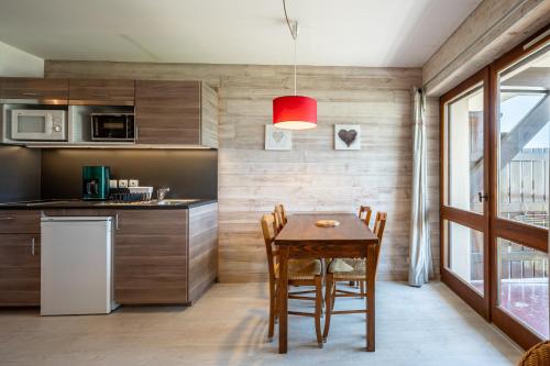 une cuisine avec une table en bois et une lumière rouge dans l'établissement Studio 13 - L'Étale, à Cohennoz