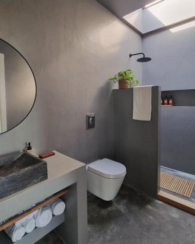 a bathroom with a sink and a toilet and a mirror at eftopia in Balodhimaíika