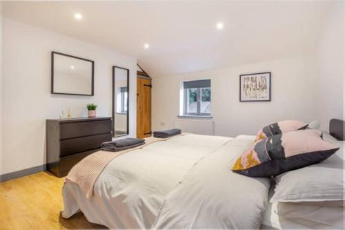 a white bedroom with a large bed and a dresser at Zest Homes 87 Bridge Street in Leominster