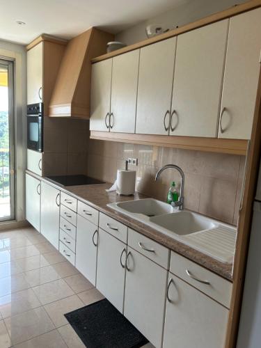 une cuisine avec des placards blancs et 2 lavabos dans l'établissement Elegant apartment a Nice, Sea View, à Nice