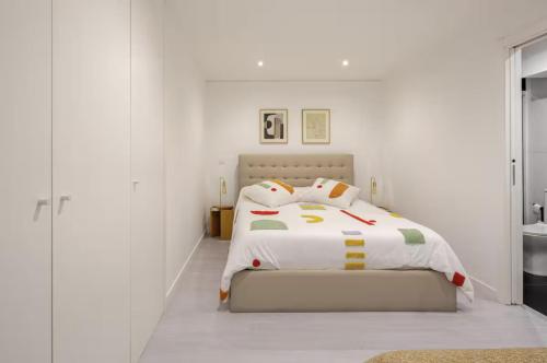 a white bedroom with a bed with white walls at Algae n'areia in Moledo