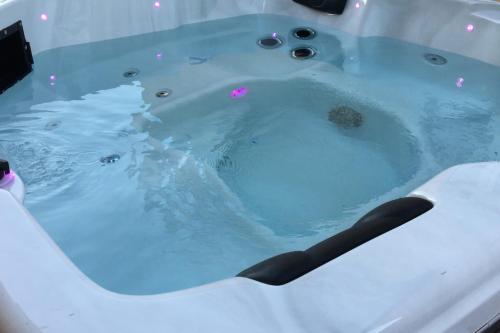 une baignoire remplie d'eau bleue dans l'établissement Villa Et au milieu coule un ruisseau - Piscine, jacuzzi privé, boulodrome, à Berlou