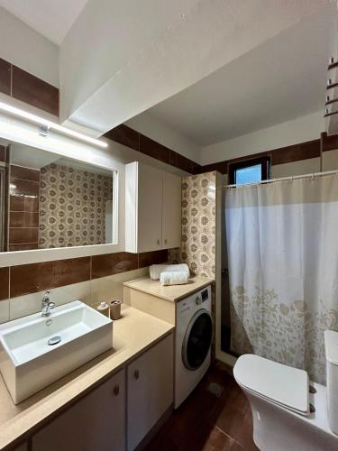 a bathroom with a sink and a washing machine at Serenity in Kefalos