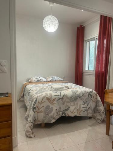 une chambre avec un lit avec une couette et une fenêtre dans l'établissement La Mascotte, à Nice