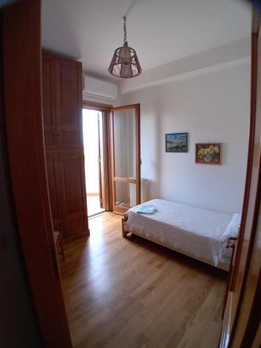 a bedroom with a bed and a hallway with a window at Carachouse Pellaro in Pellaro