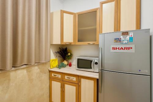 a kitchen with a refrigerator and a microwave at Cosy One bedroom Appartment with open balcony terrace, near Opera, Tumanyan & Pushkin streets, Self Check in, city centre, Yerevan in Yerevan