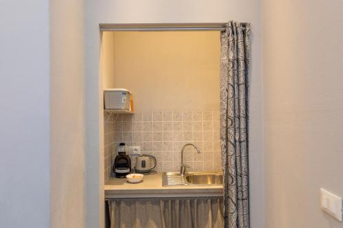 a kitchen with a sink and a mirror at L'incanto in Montescudaio