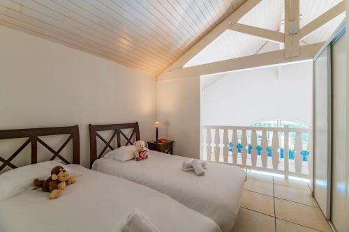 - deux lits avec des ours en peluche dans une chambre dans l'établissement Lagrange Vacances - Atlantic Green, à Lacanau-Océan