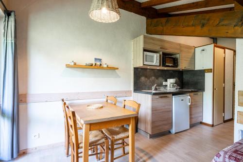 Il comprend une cuisine équipée d'une table et de chaises. dans l'établissement Studio 11 - Les Warrens, à Cohennoz