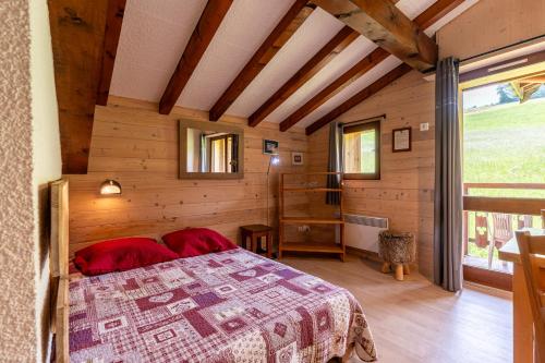 - une chambre avec un lit dans une maison en bois dans l'établissement Studio 11 - Les Warrens, à Cohennoz