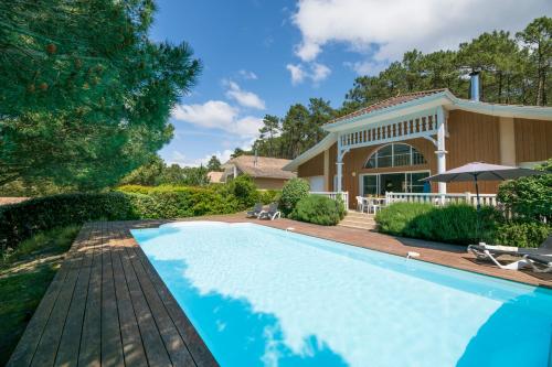 une piscine devant une maison dans l'établissement Lagrange Vacances - Atlantic Green, à Lacanau-Océan