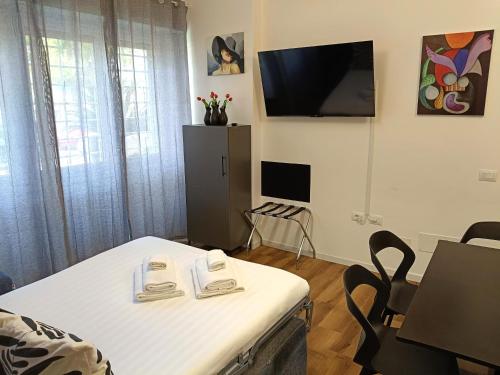a room with a bed and a table and a tv at Ancient Rome Colosseum modern and bright apartment in Rome