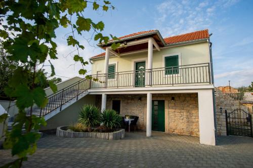 a house with a balcony and a staircase at Villa Magic with heated pool in Trbounje