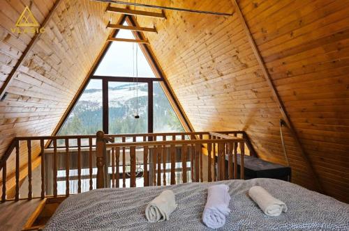 a bed in a room with a large window at Weekend house - Vlašić in Vlasic